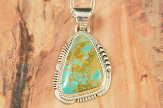 Genuine Manassa Turquoise set in Sterling Silver Pendant. This Turquoise is also referred to as King�s Manassa Turquoise. The Manassa Turquoise mine is located in Manassa, Conejos County, Colorado. Created by Navajo Artist John Nelson. Signed. Free 18